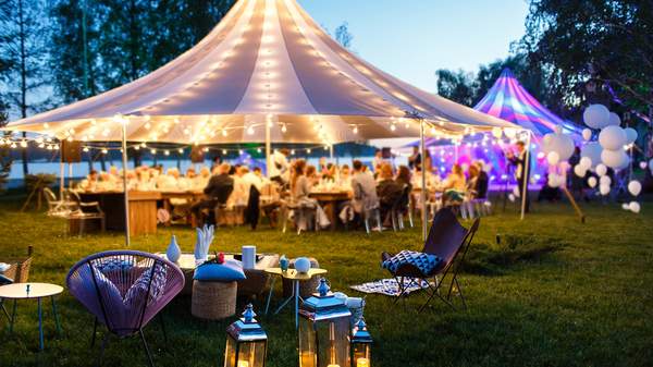 Partydekoration im Hintergund ein riesiges Party-Zelt hell erleuchtet