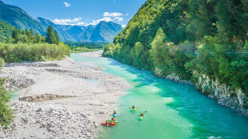 Ein natürlicher und klarer Fluss schlängelt sich durch Berge und Wälder