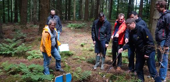 Eine Gruppe von Menschen spielt im Wald Crossgolf