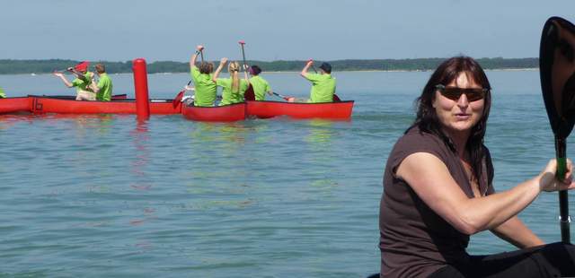 Birgit Fischer im Kanu Birgit Fischer sitzt im Kanu auf dem Wasser. Im Hintergrund sieht man mehrere Kanus.