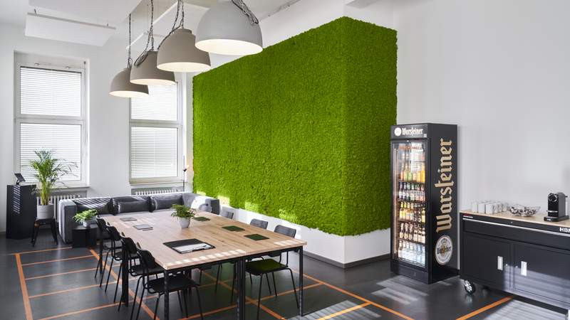 Unsere Green Lounge mit Meetingtisch, Kühlschrank und Kaffeebar.