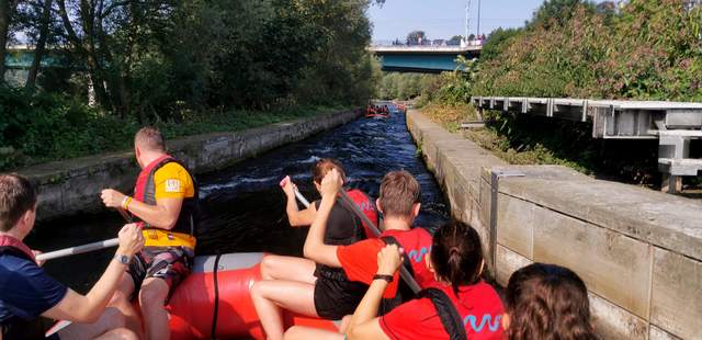 Rafting als Teamevent Rudernde Menschen in einem Raftingboot