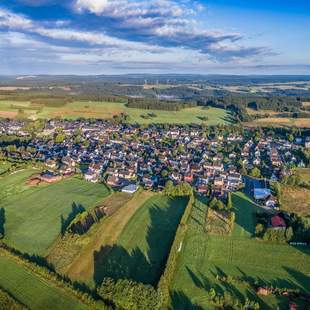 Luftaufnahme von Teuschnitz mit Wiesen und Wälder im Hintergrund