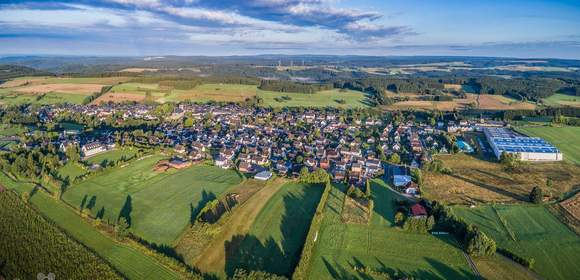 Luftaufnahme von Teuschnitz mit Wiesen und Wälder im Hintergrund