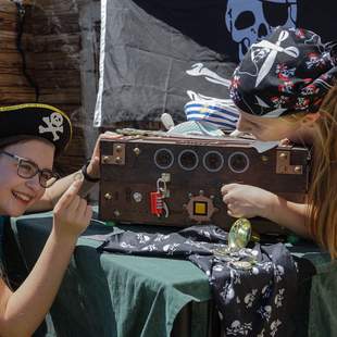 2 Frauen versuchen die Escape Box der Piratenschatzsuche zu öffnen