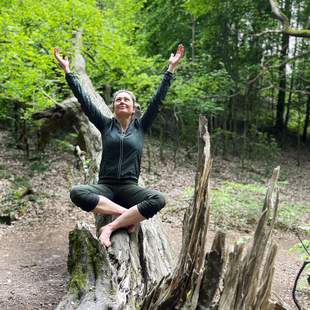 Frau im Schneidersitz , Arme nach , Blick in den Himmel