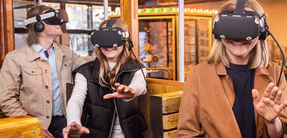 Menschen mit VR-Brille im Nachbau einer alten Tram