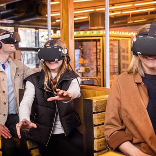 Menschen mit VR-Brille im Nachbau einer alten Tram