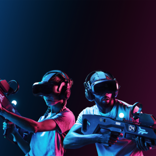 Zero Latency Hannover Eine Frau und ein Mann tragen Virtual Reality Brillen und Gewehrcontroller und sehen konzentriert aus.