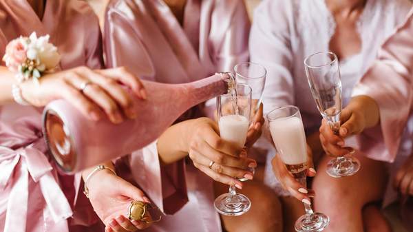 Frauen in Bademänteln, die mit Sekt anstoßen